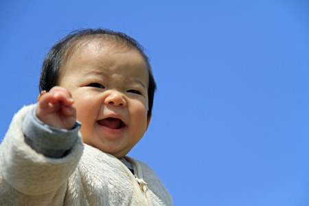 Baby boy under blue skyの写真素材