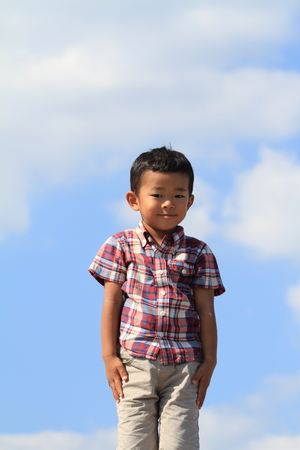 Smiling Japanese boy under the blue skyの写真素材