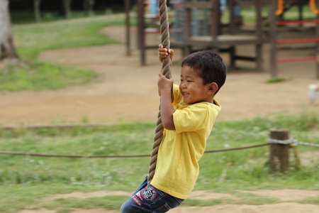 Japanese boy playing with Tarzan rope (3 years old)の写真素材