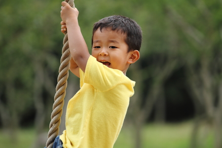 Japanese boy playing with Tarzan rope (3 years old)の写真素材