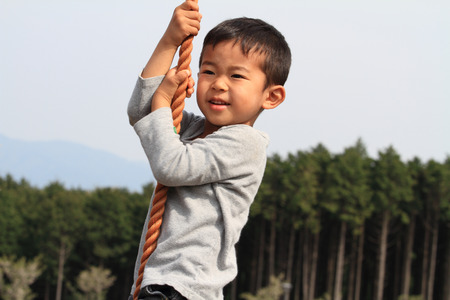 Japanese boy playing with tarzan ropeの写真素材