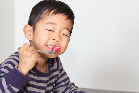Japanese boy eating strawberryの写真素材