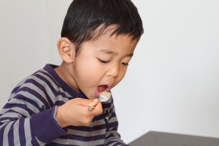 Japanese boy eating cerealの写真素材
