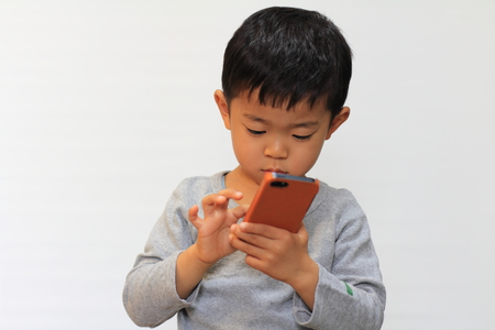 Japanese boy using smart phoneの写真素材