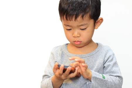 Japanese boy using smart phoneの写真素材
