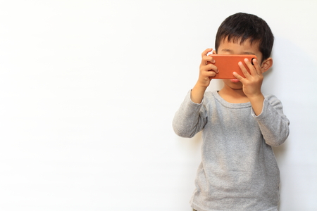 Japanese boy using smart phoneの写真素材