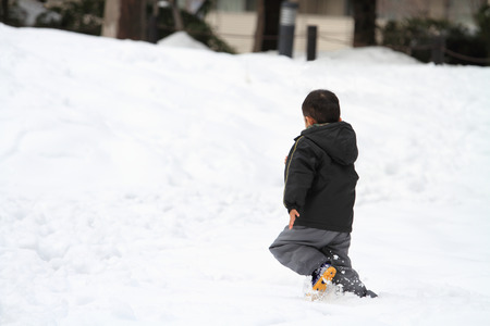 Japanese boy running on the snow fieldの写真素材