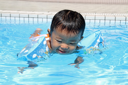 Japanese boy swiming in the pool (1 year old)の写真素材