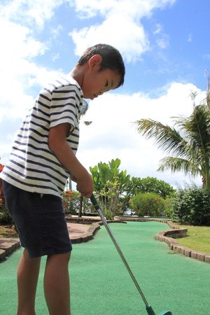 Japanese boy playing with putting golf 5 years oldの写真素材