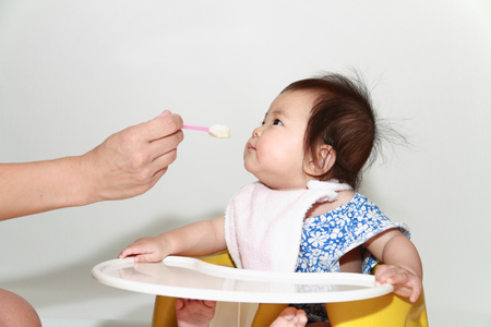 Japanese baby girl eating baby food (0 year old)の写真素材
