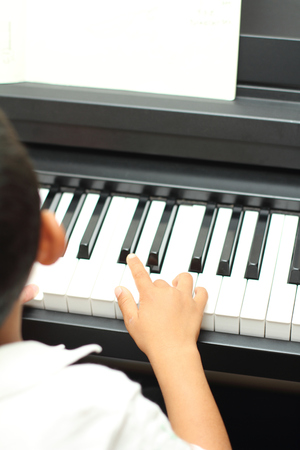 Japanese boy playing a piano (5 years old)の写真素材