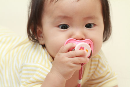 Japanese baby girl sucking on a pacifier (0 year old)