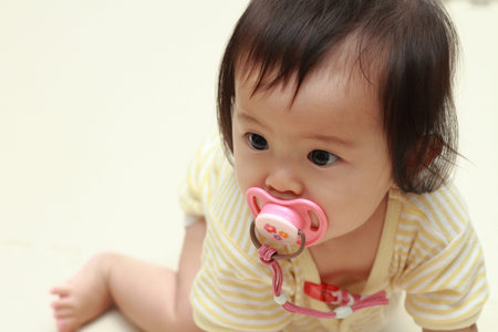 Japanese baby girl sucking on a pacifier (0 year old)