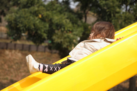 Japanese baby girl on the slide (1 year old)の写真素材