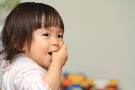 Japanese baby girl sucking her finger (1 year old)の写真素材