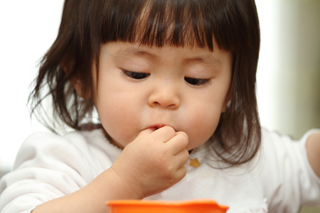 Japanese baby girl eating cereal (1 year old)の写真素材