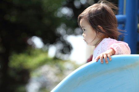 Japanese girl on the slide (1 year old)の写真素材