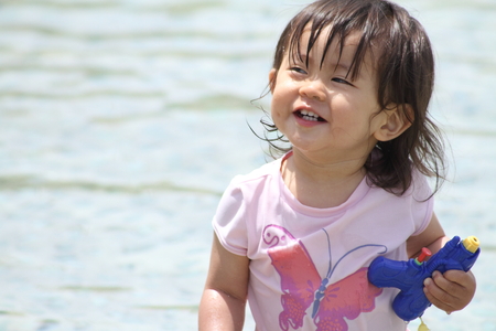 Japanese girl playing with water (1 year old)の写真素材