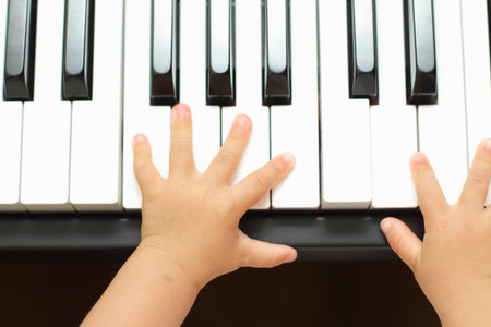 Hands of Japanese girl playing a piano (1 year old)の写真素材