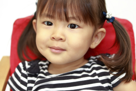 Japanese girl sitting on the chair (2 years old) (white back)の写真素材