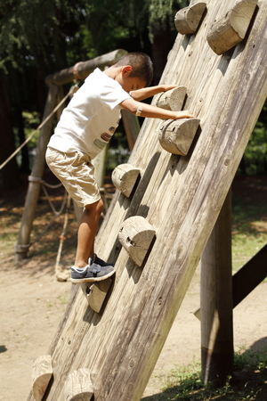 Japanese boy climbing on the wall (second grade at elementary school)の写真素材