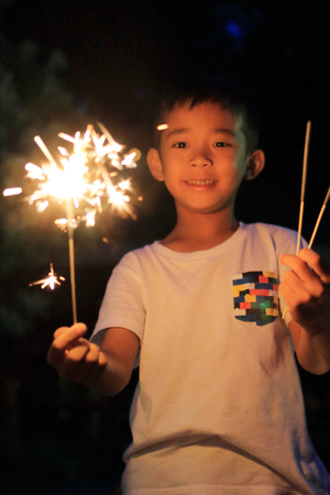 Japanese boy doing handheld fireworks (second grade at elementary school)の写真素材