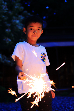 Japanese boy doing handheld fireworks (second grade at elementary school)の写真素材