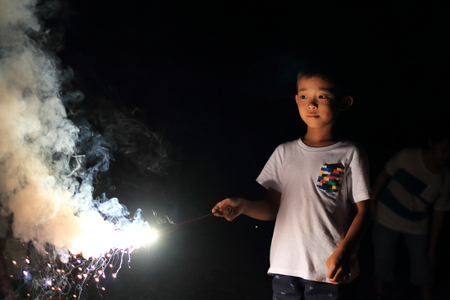 Japanese boy doing handheld fireworks (second grade at elementary school)の写真素材