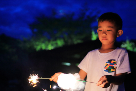 Japanese boy doing handheld fireworks (second grade at elementary school)の写真素材