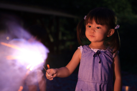 Japanese girl doing handheld fireworks (2 years old)の写真素材