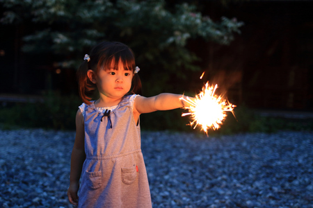 Japanese girl doing handheld fireworks (2 years old)の写真素材
