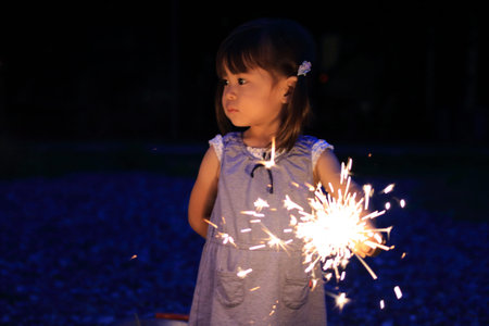 Japanese girl doing handheld fireworks (2 years old)の写真素材