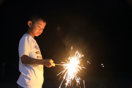 Japanese boy doing handheld fireworks (second grade at elementary school)の写真素材