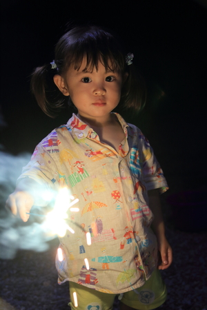 Japanese girl doing handheld fireworks (2 years old)の写真素材