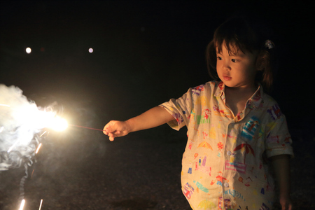 Japanese girl doing handheld fireworks (2 years old)の写真素材