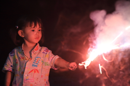 Japanese girl doing handheld fireworks (2 years old)の写真素材