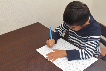 Japanese boy doing homework (second grade at elementary school)の写真素材