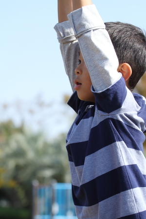 Japanese boy playing with a monkey bars (second grade at elementary school)の写真素材