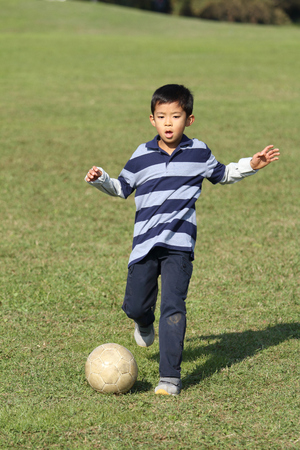 Japanese boy playing with soccer ball (second grade at elementary school)の写真素材