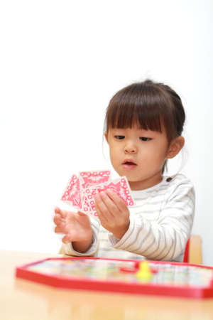 Japanese girl playing with boardgame (3 years old)の写真素材