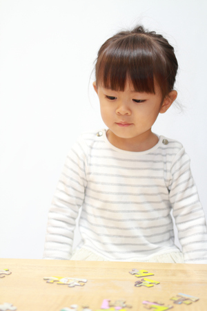 Japanese girl doing jigsaw puzzle (3 years old)の写真素材