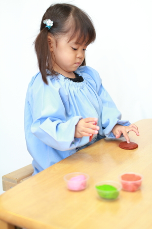 Japanese girl playing with clay (3 years old)の写真素材