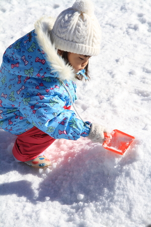 Japanese girl playing in the snow (3 years old)の写真素材