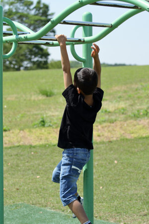 Japanese boy playing with a monkey bars (third grade at elementary school)