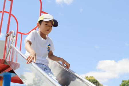 Japanese boy on the slide (third grade at elementary school)の写真素材