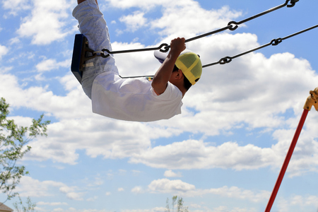 Japanese boy on the swing (third grade at elementary school)の写真素材
