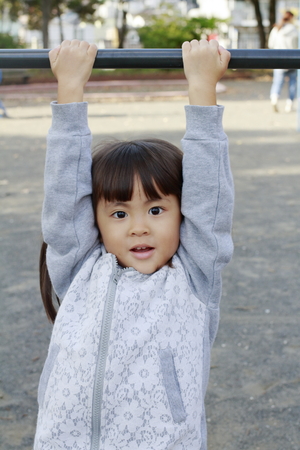 Japanese girl playing with high bar (4 years old)の写真素材