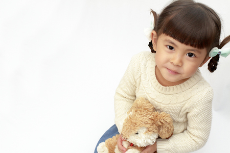 Japanese girl holding a stuffed rabbit (4 years old) (white back)の写真素材
