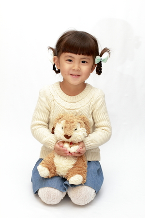 Japanese girl holding a stuffed rabbit (4 years old) (white back)の写真素材