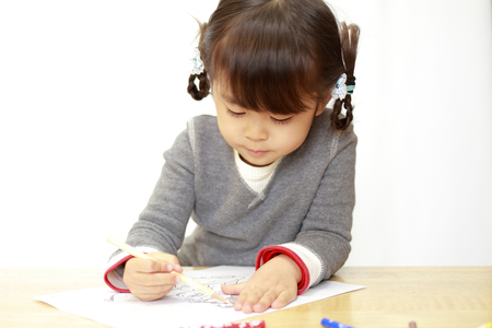 Japanese girl drawing a coloring book (4 years old)の写真素材